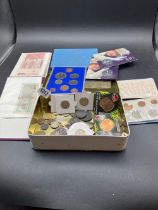 A tin of world coins and small bank not album