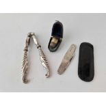 A pair of silver handled nut crackers, a cased thimble and a silver sided two blade knife by EV