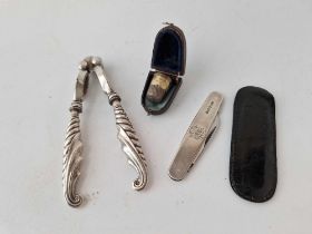 A pair of silver handled nut crackers, a cased thimble and a silver sided two blade knife by EV