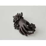 A large Victorian mourning brooch of hand holding flowers