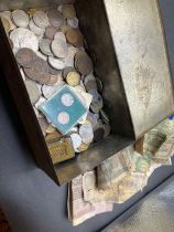 A tin of world coins and bank notes