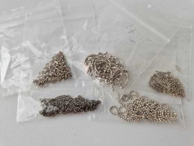 A bag of five silver neck chains