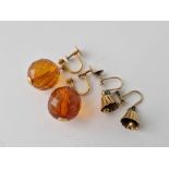 A pair of bell shaped earrings and another pair