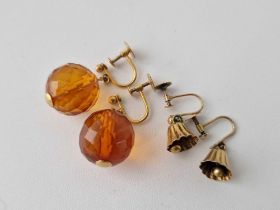 A pair of bell shaped earrings and another pair