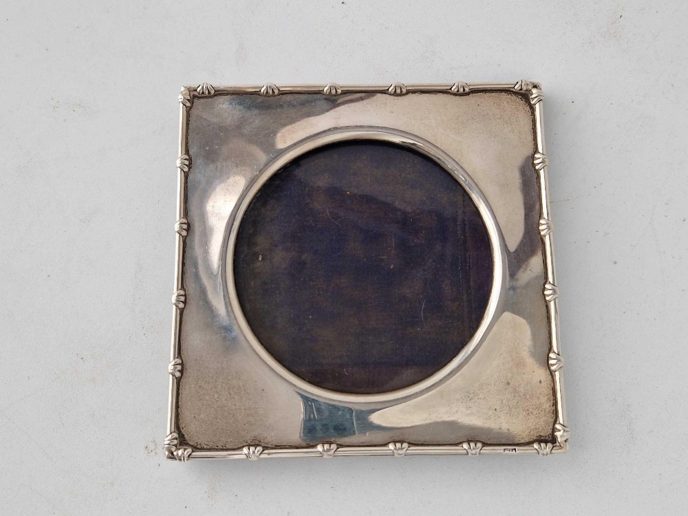 A square photo frame with decorated rim and circular aperture, 5 inches high, London 1906 by WC