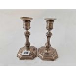 A pair of George I style candlesticks with shaped square bases and baluster stems, 6" high,