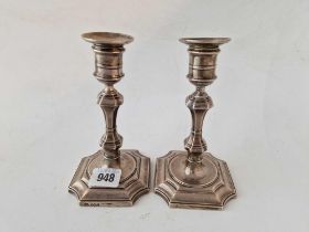 A pair of George I style candlesticks with shaped square bases and baluster stems, 6" high,