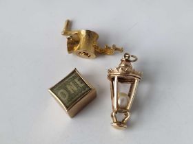 Three 9ct charms, a lantern, £1 note charm and a mincer 11.5g