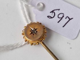 A gold and diamond topped stick pin