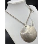 A large designer hammered silver pendant on silver chain 43 gms