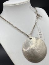 A large designer hammered silver pendant on silver chain 43 gms