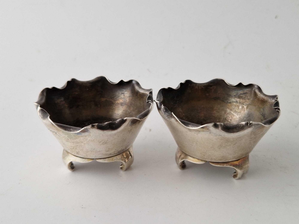 A pair of stylish salts with wavy rims bracket feet, 2.25 inches wide, London 1883 by JWH & JTH,