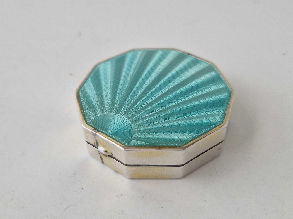 An octagonal compact with green enamel cover, 2 inches wide,