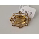 A oval brooch with large central citrine with floral pearl surround