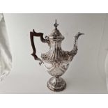 An early George III coffee pot, chased with drapery and beaded edges and crest, 12 inches high,