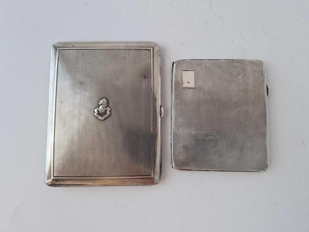 Two cigarette cases, one applied with a crest. 220gms