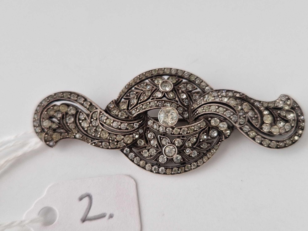 A silver and white art deco brooch