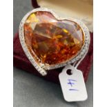 A OVERSIZED SILVER FRENCH HEART SHAPED ORANGE CITRINE GEM STONE AND WHITE SAPPHIRE RING WITH FIVE