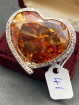 A OVERSIZED SILVER FRENCH HEART SHAPED ORANGE CITRINE GEM STONE AND WHITE SAPPHIRE RING WITH FIVE