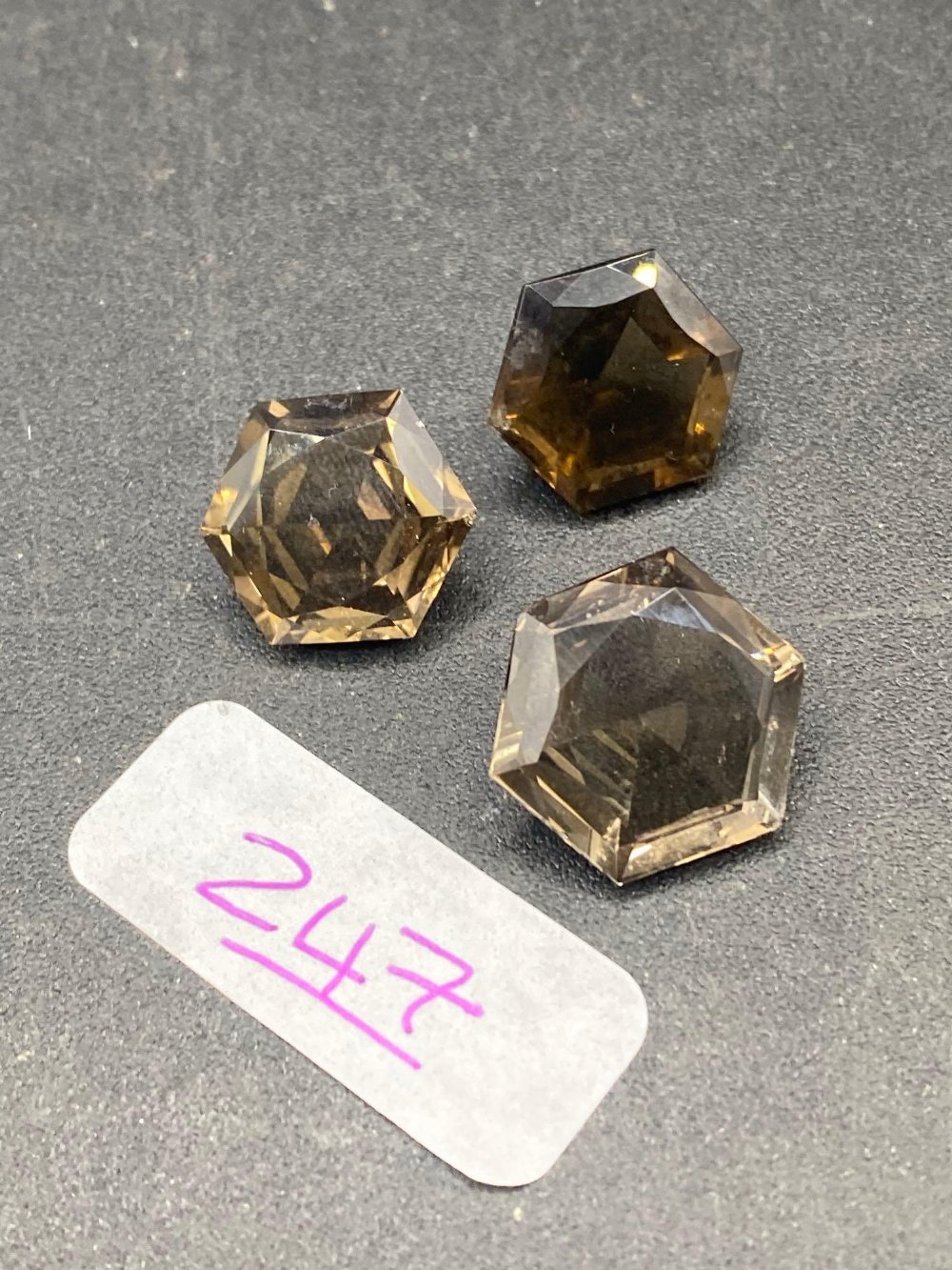 A pair of matched octagonal smokey quartz gem stones with a larger single gem stone to match 28