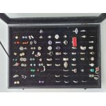 A ring display case containing 46 silver rings and 22 complete pairs of silver earrings