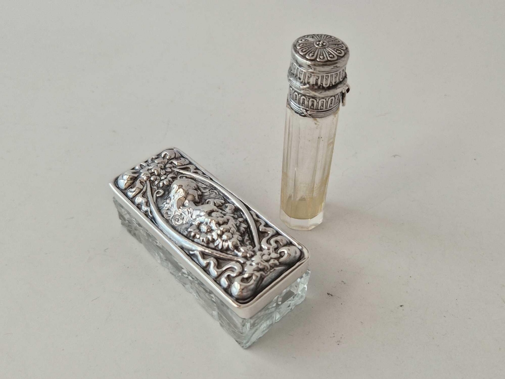 An embossed top dressing table jar, stamped STERLING and a scent bottle. Both with glass bodies