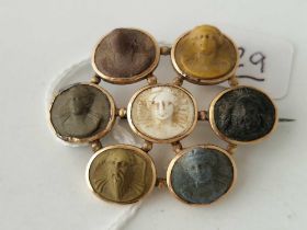 A Victorian gold mounted brooch set with seven lava cameo of varying colours