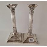 A pair of candlesticks with step square bases, fluted stems and detatchable nozzles, 9.5" high,