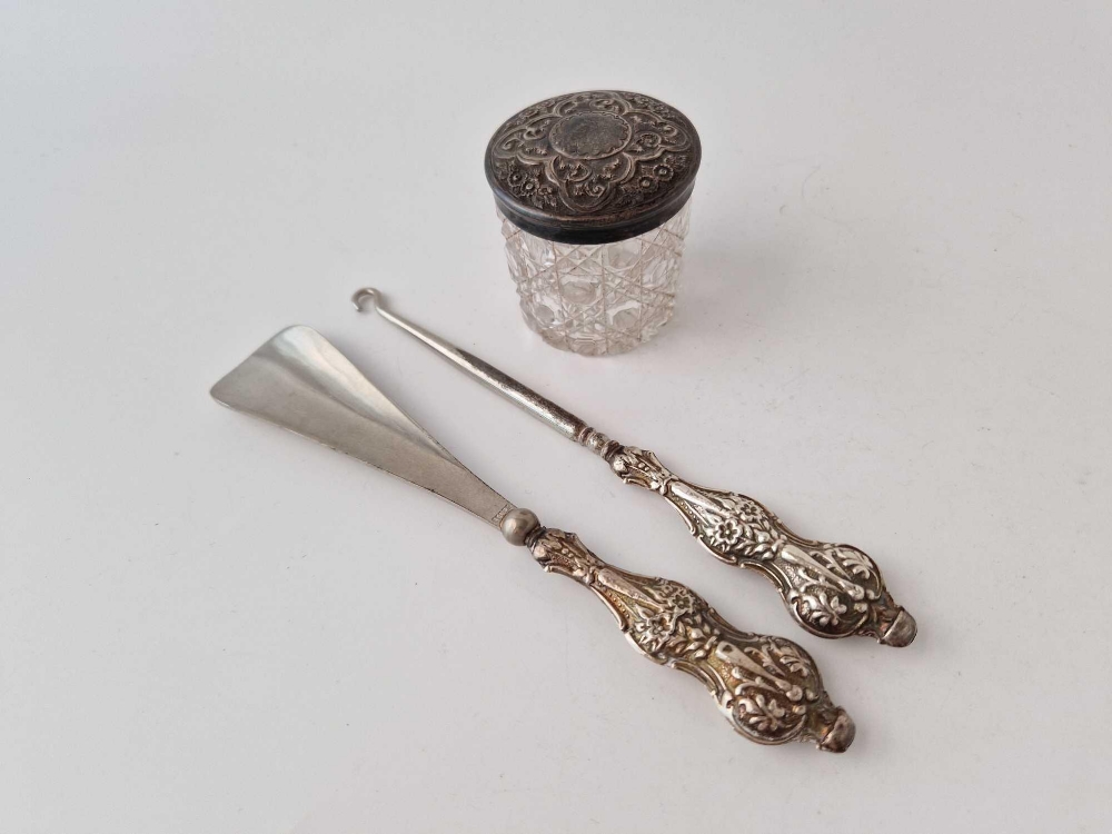 Embossed top jar, Birmingham 1899, a button hook and a shoe horn