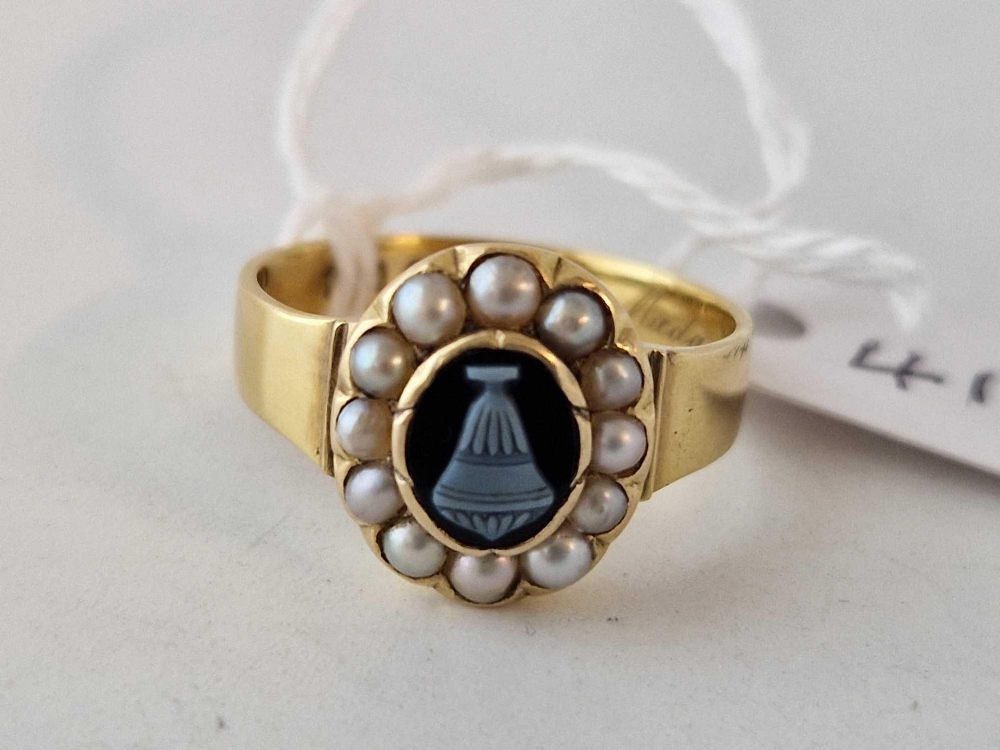 A VICTORIAN MOURNING RING 18CT GOLD WITH A CENTRAL HARD STONE URN CAMEO SURROUNDED BY PEARLS