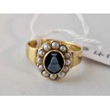 A VICTORIAN MOURNING RING 18CT GOLD WITH A CENTRAL HARD STONE URN CAMEO SURROUNDED BY PEARLS
