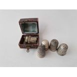 A boxed silver thimble and four other silver thimbles