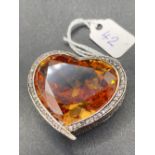 A OVERSIZED SILVER FRENCH HEART SHAPED ORANGE CITRINE GEM STONE AND WHITE SAPPHIRE PENDANT