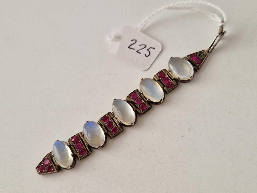 Part of a silver bracelet set with five moonstones and red stones