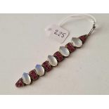 Part of a silver bracelet set with five moonstones and red stones