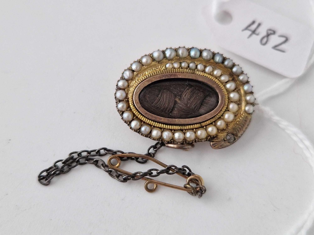 A 19th century pearl mourning brooch with gold snake pearl surround