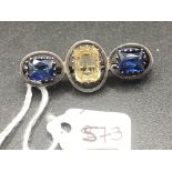 A silver blue and yellow three stone paste set brooch