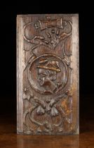 A 16th Century Carved Oak Romayne Portrait Panel centred by the profiled head of a man in a roundel