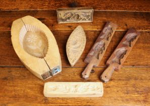 A Group of Treen Moulds: A navette shaped pie mould having a separate base carved with a flower and