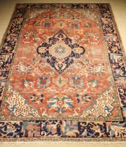 An Antique Heriz Carpet having a large lozenge shaped centre medallion on a red ground field woven