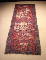 An Antique Caucasian Rug (A/F) 141" x 56" (258 cm x 142 cm).