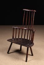An 18th Century Primitive Comb-back Windsor Armchair with residual paint-work.