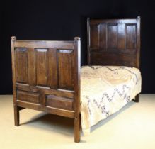An 18th Century Style Panelled Oak Three-quarter width Bed.