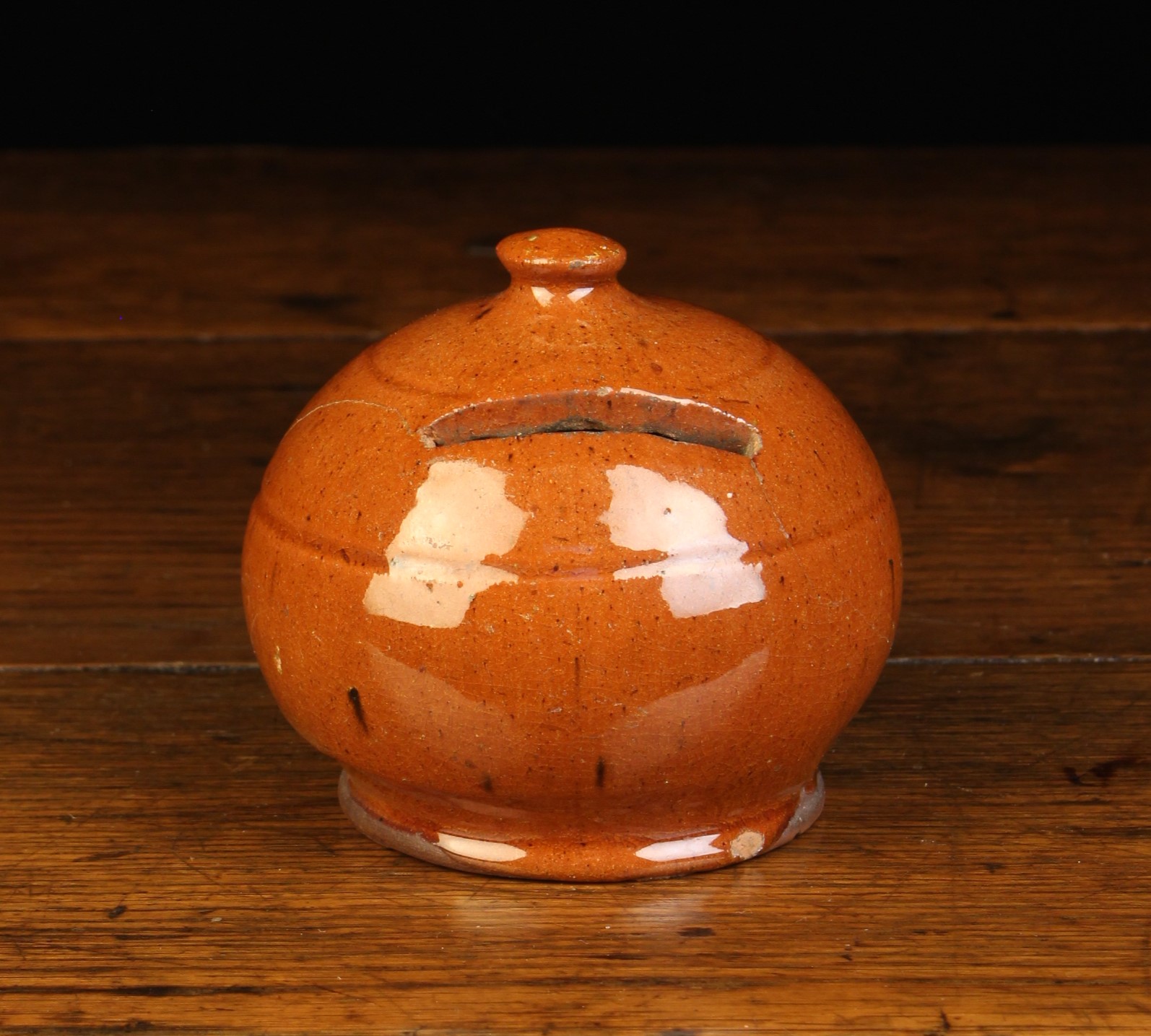 A Small Sussex Red Earthenware Money Box of squat bulbous form with flattened finial knop and