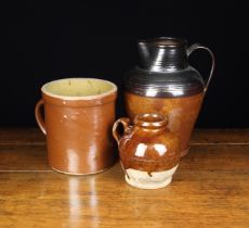 Three 19th Century Stoneware Vessels: A large jug with dark treacle glaze to the ring-turned neck,