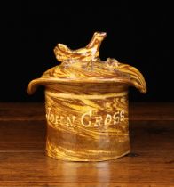 A Halifax Agate-ware Tobacco Jar modelled as a top hat marbled in yellow and brown and having a