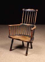 An 18th Century Primitive Windsor Comb-back Armchair with residual green paintwork.