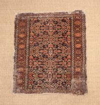 An Antique Persian Rug (worn) 35" x 30½" (89 cm x 78 cm).