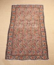 An Antique Senneh Rug woven with repeated floral design on an ivory ground framed by an undulating