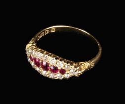 An 18 Carat Gold Lady's Ring set with five graduated oval cut rubies framed by a border of 17 small